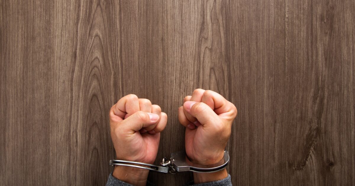 image-arrested-criminal-hands-locked-in-handcuffs